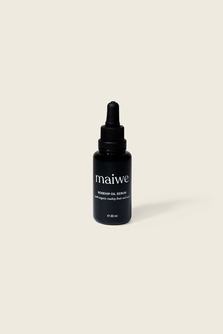 A black dropper bottle with white label containing rosehip oil serum.